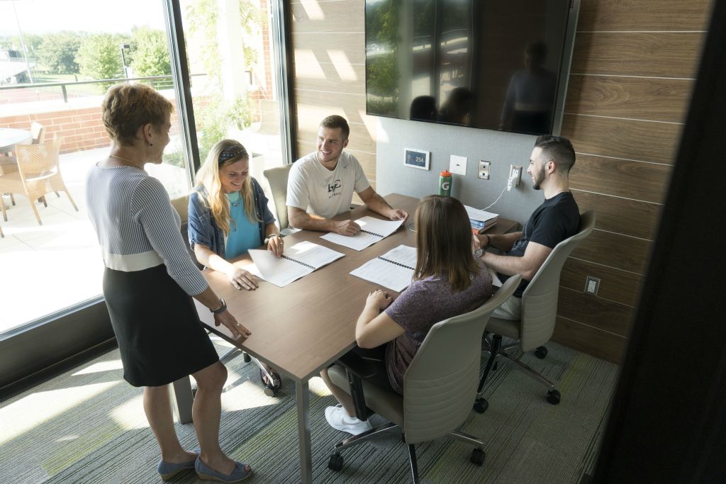 Students connect with a professor in one of the study rooms